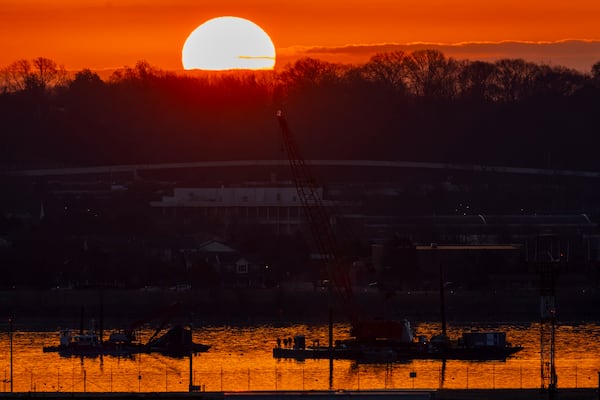 Salvage crews work near the wreckage site in the Potomac River of a mid-air collision between an American Airlines jet and a Black Hawk helicopter, at Ronald Reagan Washington National Airport, Tuesday, Feb. 4, 2025, in Arlington, Va. (AP Photo/Ben Curtis)