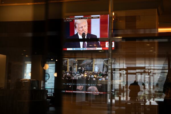 The inauguration of U.S. President Donald Trump is seen through reflections as it plays live on screens in the lobby of a building in Halifax, Nova Scotia, on Monday, Jan. 20, 2025. (Darren Calabrese/The Canadian Press via AP)