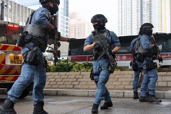 Armed police officers stand guard outside the West Kowloon Magistrates' Courts in Hong Kong Tuesday, Nov. 19, 2024. (AP Photo/Chan Long Hei)