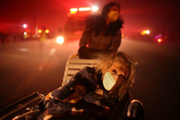 FILE - Residents and staff at Pasadena Park Healthcare & Wellness Center evacuate as the Eaton Fire approaches on Jan. 7, 2025, in Altadena, Calif. (AP Photo/Ethan Swope, File)