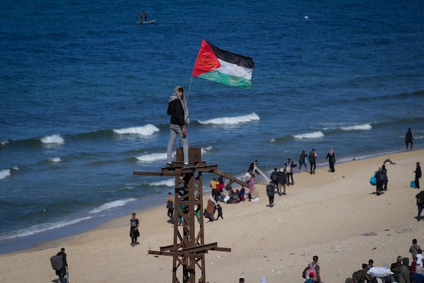 A boy holds a Palestinian flag as displaced Palestinians return to their homes in the northern Gaza Strip, following Israel's decision to allow thousands of them to go back for the first time since the early weeks of the 15-month war with Hamas, Monday, Jan. 27, 2025. (AP Photo/Abdel Kareem Hana)