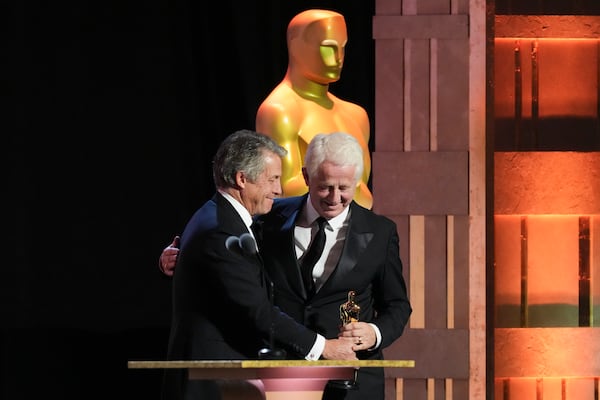 Hugh Grant, left, presents Richard Curtis with the Jean Hersholt Humanitarian Award during the 15th Governors Awards on Sunday, Nov. 17, 2024, at The Ray Dolby Ballroom in Los Angeles. (AP Photo/Chris Pizzello)