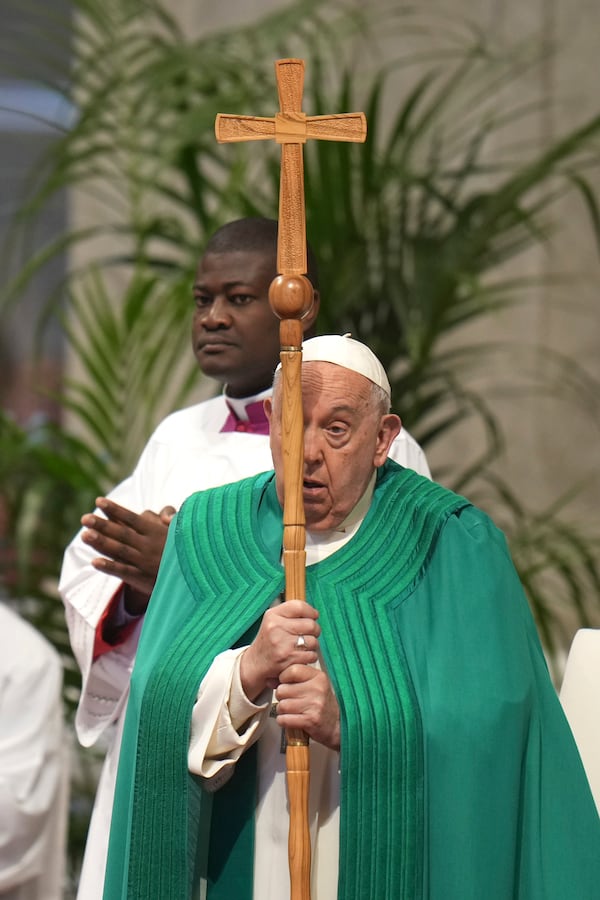 Pope Francis holds the cross as he presides over a mass on the occasion of the World Day of the Poor in St. Peter's Basilica, at the Vatican, Sunday, Nov. 17, 2024. (AP Photo/Alessandra Tarantino)