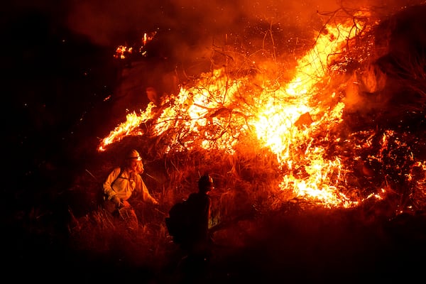 Firefighters battle the Lilac Fire along Interstate 15 near the Bonsall community of San Diego County, Calif., on Tuesday, Jan. 21, 2025. (AP Photo/Noah Berger)