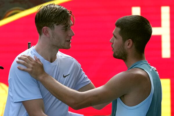 Carlos Alcaraz, right, of Spain is congratulated by Jack Draper of Britain, left after Draper retires from their fourth round match at the Australian Open tennis championship in Melbourne, Australia, Sunday, Jan. 19, 2025. (AP Photo/Mark Baker)