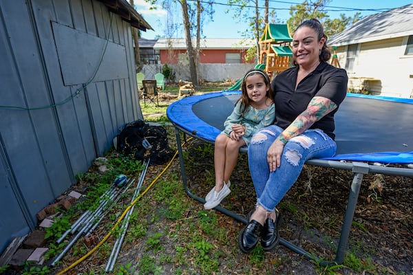 Cecila Grove and her daughter Aria Grove sit outside their home Saturday, Nov. 16, 2024, in Sarasota, Fla. (AP Photo/Steve Nesius)