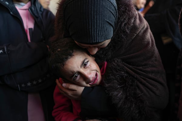 A child reacts next to the bodies of his relatives who were killed in the Israeli bombardment of the Gaza Strip at Al-Aqsa Hospital in Deir Al-Balah, Tuesday, Jan. 14, 2025. (AP Photo/Abdel Kareem Hana)