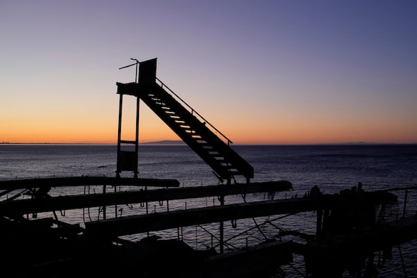 The sun rises behind a fire-ravaged beachfront property in the aftermath of the Palisades Fire Monday, Jan. 13, 2025 in Malibu, Calif. (AP Photo/John Locher)