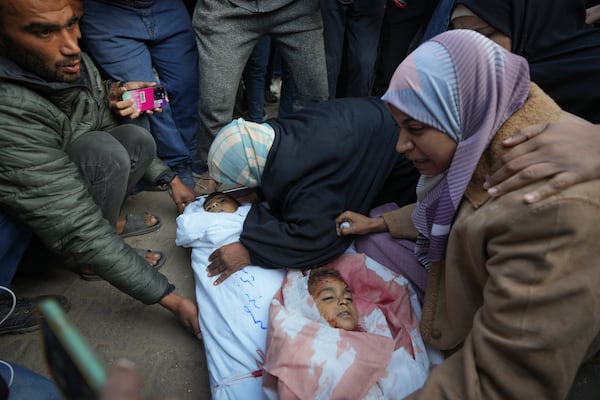 Areej al Qadi right mourns over the bodies of her three children before their funeral in Deir al-Balah, Gaza Strip, Thursday Nov. 21, 2024. Seven-year-old Hamza, his five-year-old brother Abdelaziz, and his four-year-old sister Laila Hassan were among 9 people killed by an Israeli strike in Khan Younis on Wednesday. Palestinian health officials say the death toll in the Gaza Strip from the 13-month-old war between Israel and Hamas has surpassed 44,000. (AP Photo/Abdel Kareem Hana)