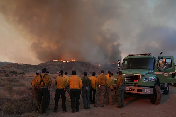 Workers monitor flames caused by the Hughes Fire is seen in Castaic, Calif., Wednesday, Jan. 22, 2025. (AP Photo/Marcio Jose Sanchez)