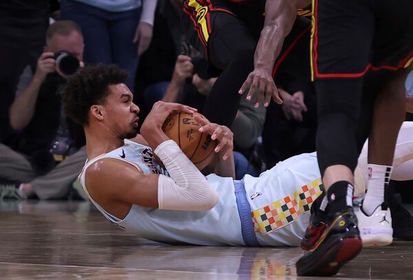 San Antonio Spurs center Victor Wembanyama, left, fights to keep control of the ball against the Atlanta Hawks during overtime of an NBA basketball game in San Antonio, Thursday, Dec. 19, 2024. Spurs defeated the Hawks, 133-126. (AP Photo/Kin Man Hui)