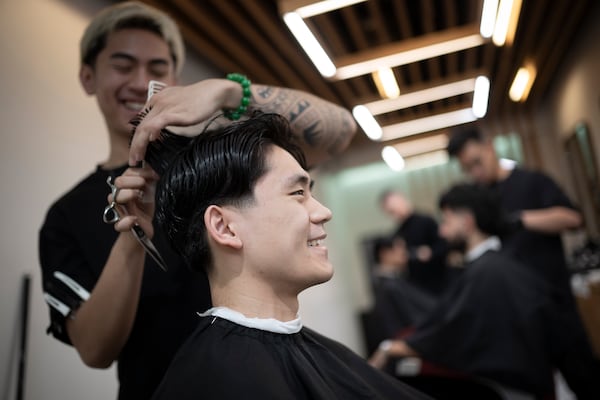 Barbers work on their clients at 12 Pell, a local barbershop in Manhattan's Chinatown, Thursday, Jan. 25, 2024, in New York. (AP Photo/John Minchillo)