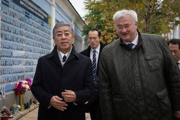 Japanese Foreign Minister Takeshi Iwaya, left, and Ukraine's Foreign Minister Andriiy Sybiha after a flower laying ceremony at the memorial wall of the fallen soldiers in Kyiv, Ukraine, Saturday, Nov. 16, 2024. (AP Photo/Efrem Lukatsky)