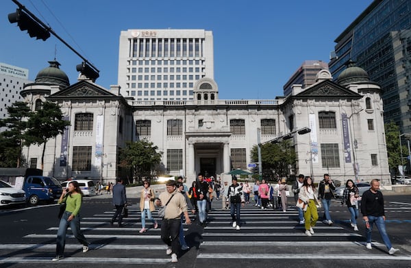 FILE - People pass by the headquarters of the Bank of Korea in Seoul, South Korea, Oct. 16, 2019. (AP Photo/Ahn Young-joon, File)