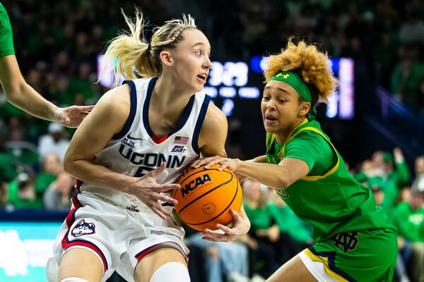 Notre Dame guard Hannah Hidalgo, right, tries to steal the ball from UConn guard Paige Bueckers, left, during the first half of an NCAA college basketball game Thursday, Dec. 12, 2024, in South Bend, Ind. (AP Photo/Michael Caterina)