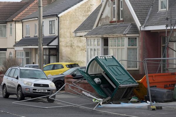 A fence and a mobile toilet blown over by the wind as Storm Eowyn hits the country in Blackpool, England, Friday, Jan. 24, 2025.(AP Photo/Jon Super)