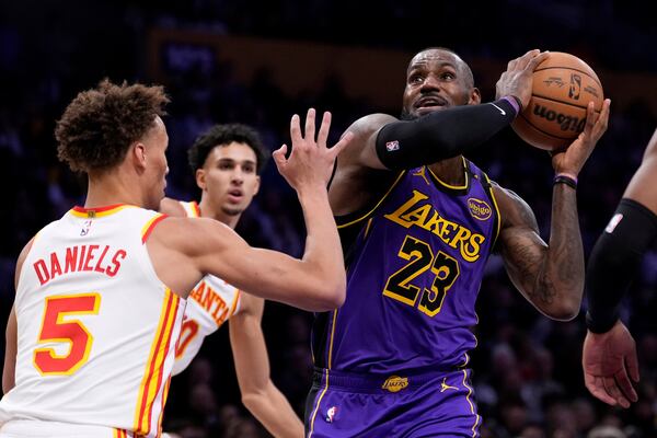 Los Angeles Lakers forward LeBron James, right, shoots as Atlanta Hawks guard Dyson Daniels defends during the first half of an NBA basketball game, Friday, Jan. 3, 2025, in Los Angeles. (AP Photo/Mark J. Terrill)