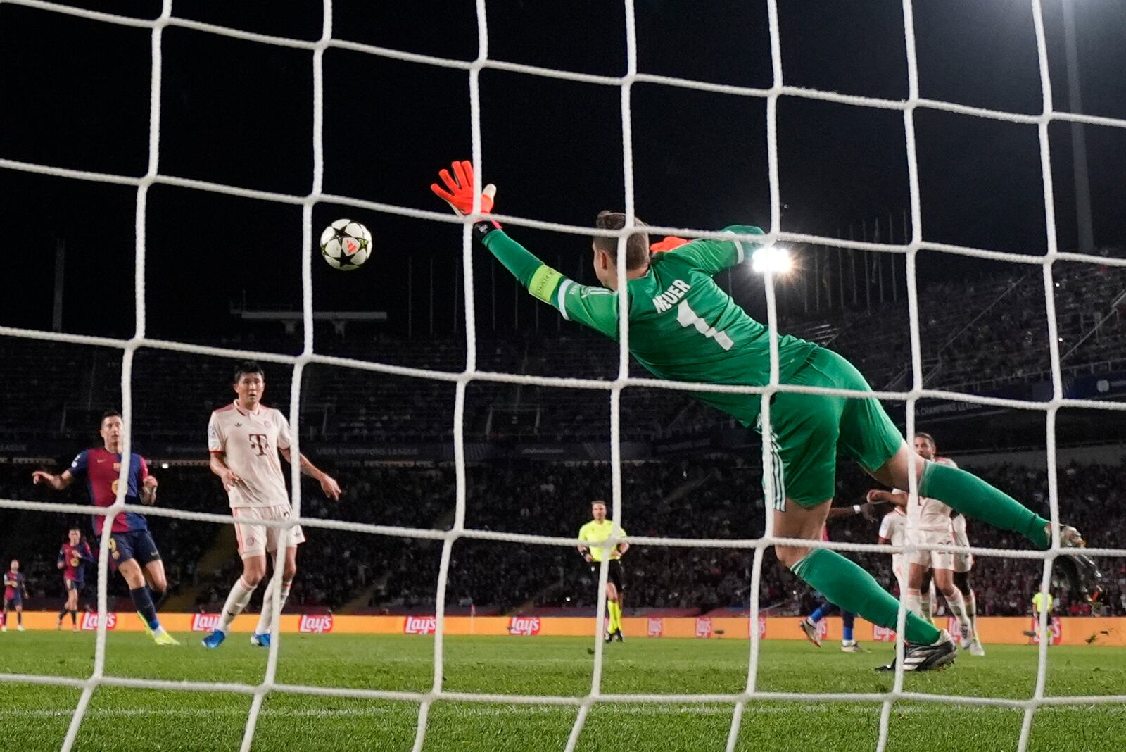 Barcelona's Raphinha, unseen, scores his side's third goal past Bayern's goalkeeper Manuel Neuer during the Champions League opening phase soccer match between Barcelona and Bayern Munich at the Lluis Companys Olympic Stadium in Barcelona, Spain, Wednesday, Oct. 23, 2024. (AP Photo/Emilio Morenatti)