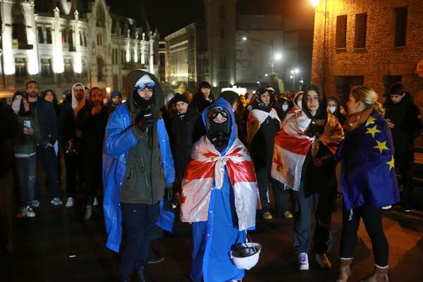 Demonstrators stand in front of police rallying to continue protests against the government's decision to suspend negotiations on joining the European Union in Tbilisi, Georgia, early Tuesday, Dec. 3, 2024. (AP Photo/Zurab Tsertsvadze)