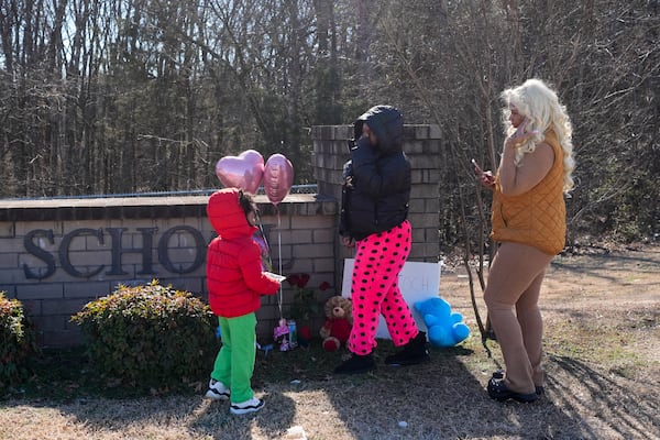 Antioch High School student Jaliana Baskin, center, visits a memorial for victims of a shooting at the school with her mother Madonna Elmore, right, and brother Jeremiah Elmore, left, Thursday, Jan. 23, 2025, in Nashville, Tenn. (AP Photo/George Walker IV)