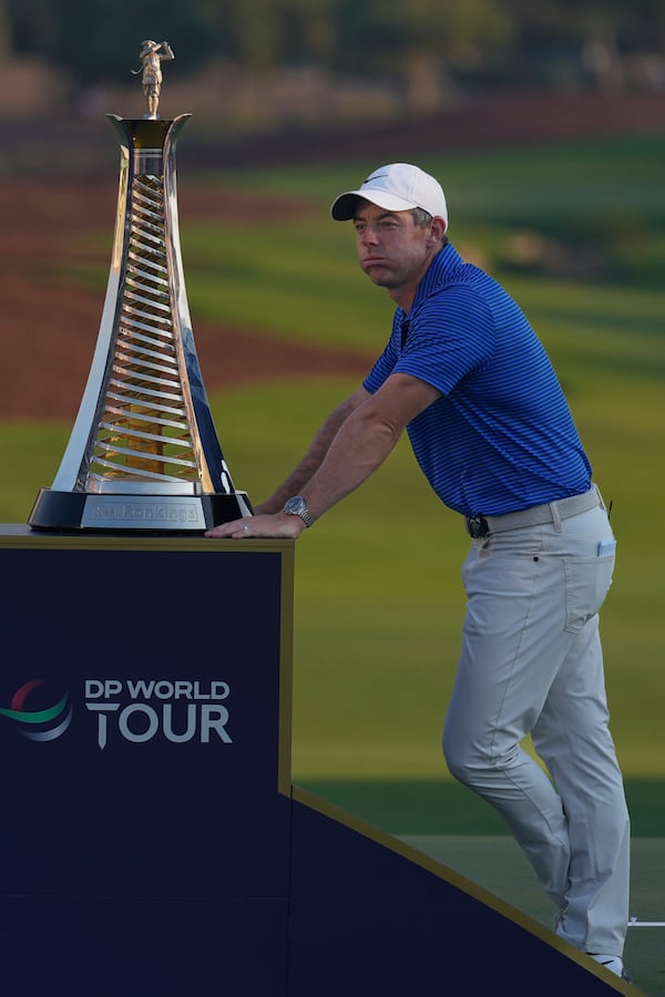 Rory McIlroy of Northern Ireland stands next Race to Dubai trophy during the award ceremony after winning the World Tour Golf Championship in Dubai, United Arab Emirates, Sunday, Nov. 17, 2024. (AP Photo/Altaf Qadri)