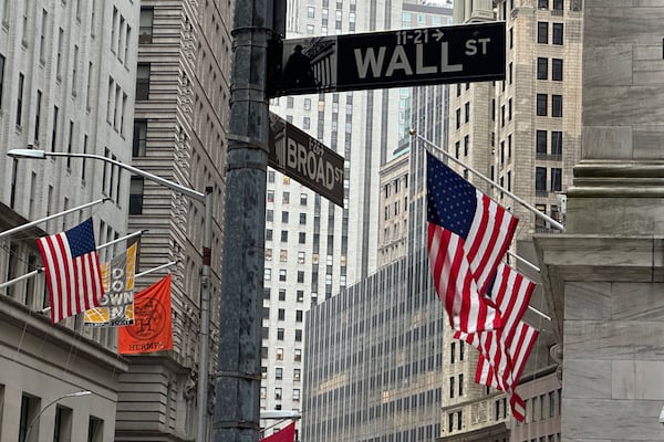 FILE - American flags hang from the front the New York Stock Exchange, right, on April 11, 2024, in New York. (AP Photo/Peter Morgan, File)