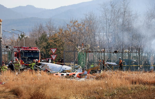 Firefighters and rescue team members work at Muan International Airport in Muan, South Korea, Sunday, Dec. 29, 2024. (Cho Nam-soo/Yonhap via AP)