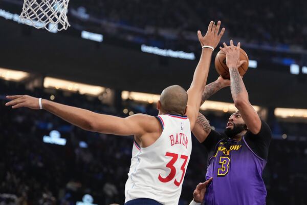 Los Angeles Lakers forward Anthony Davis, right, shoots as Los Angeles Clippers forward Nicolas Batum defends during the first half of an NBA basketball game, Sunday, Jan. 19, 2025, in Inglewood, Calif. (AP Photo/Mark J. Terrill)