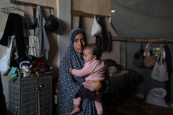 Rola Saqer holds her daughter, Massa Zaqout, who was born on the first day of the war in Gaza, in the family tent in Deir al-Balah, Gaza Strip, Tuesday, Jan. 14, 2025. (AP Photo/Abdel Kareem Hana)