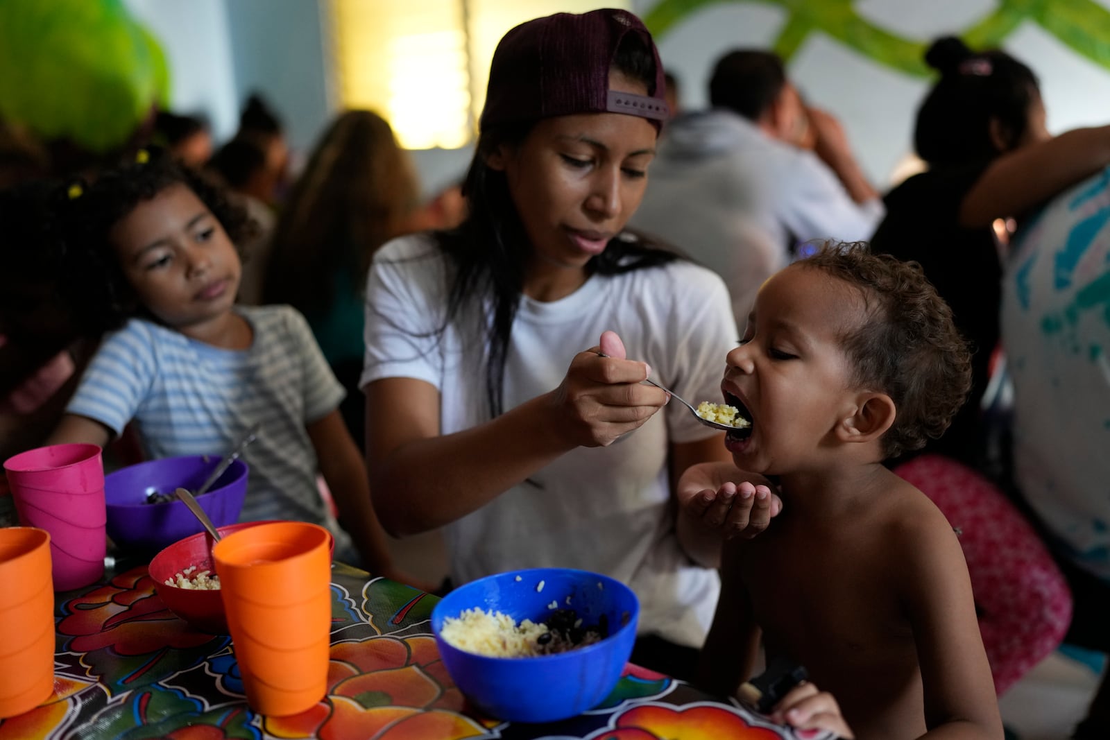 Venezuelan migrant Eyla Fonseca feeds breakfast to her son Keilerth Veloz at the Casa del Migrante shelter in Tecun Uman, Guatemala, Sunday, Oct. 27, 2024. (AP Photo/Matias Delacroix)