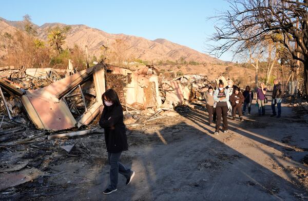 Maggie Jay, left, business office manager for the Terraces at Park Marino assisted living facility, walks past damage to the facility from the Eaton Fire with her colleagues on Monday, Jan. 13, 2025, in Pasadena, Calif. (AP Photo/Chris Pizzello)