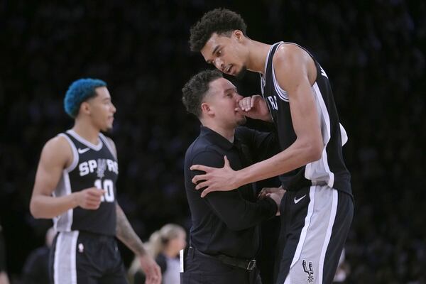 San Antonio Spurs center Victor Wembanyama, right, talks with acting head coach Mitch Johnson during the first half of a Paris Games 2025 NBA basketball game against the Indiana Pacers in Paris, Thursday, Jan. 23, 2025. (AP Photo/Thibault Camus)