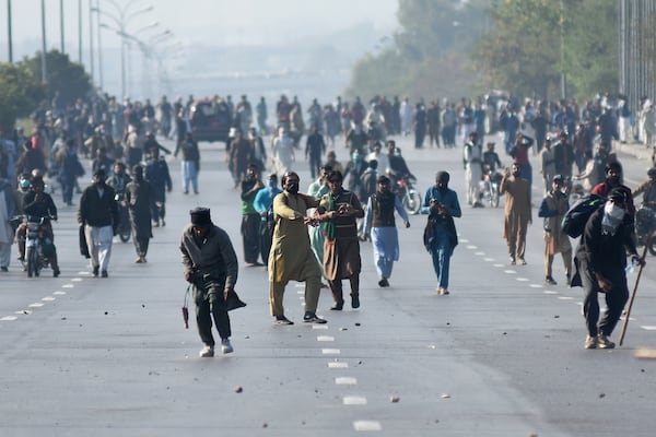 Supporters of imprisoned former premier Imran Khan's Pakistan Tehreek-e-Insaf party, throw stones towards police officers during clashes, in Islamabad, Pakistan, Tuesday, Nov. 26, 2024. (AP Photo/W.K. Yousufzai)