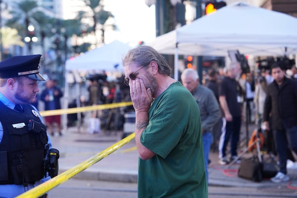 Edward Bruski, center, gets emotional at the scene where a vehicle drove into a crowd on New Orleans' Canal and Bourbon Street, Wednesday Jan. 1, 2025. (AP Photo/Gerald Herbert)