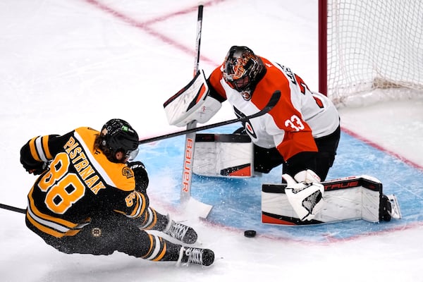 Philadelphia Flyers goaltender Samuel Ersson (33) drops to the ice to make a save on a shot by Boston Bruins right wing David Pastrnak (88) during the first period of an NHL hockey game, Tuesday, Oct. 29, 2024, in Foxborough, Mass. (AP Photo/Charles Krupa)