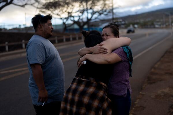 FILE - Nora Bulosan, right, and Hannah Tomas, Lahaina, Hawaii residents who survived the fire that devastated the town, comfort each other as they gather in hopes to get access to their home in Lahaina, Hawaii, Aug. 16, 2023. (AP Photo/Jae C. Hong, File)