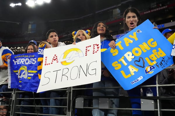 Los Angeles Rams fans hold a signs before an NFL wild card playoff football game against the Minnesota Vikings, Monday, Jan. 13, 2025, in Glendale, Ariz. (AP Photo/Ross D. Franklin)