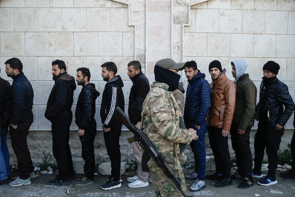 FILE - Members from Bashar Assad's Syrian army period line up to register with Syrian rebels as part of a "identification and reconciliation process" at a army compound in Latakia, Syria, Tuesday, Dec. 17, 2024. (AP Photo/Leo Correa, File)