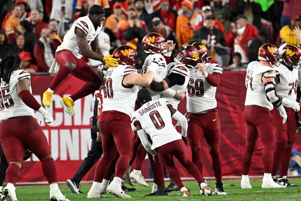 Washington Commanders place kicker Zane Gonzalez, middle, is congratulated by teammates after kicking the game winning field goal against the Tampa Bay Buccaneers during the second half of an NFL wild-card playoff football game in Tampa, Fla., Sunday, Jan. 12, 2025. (AP Photo/Jason Behnken)