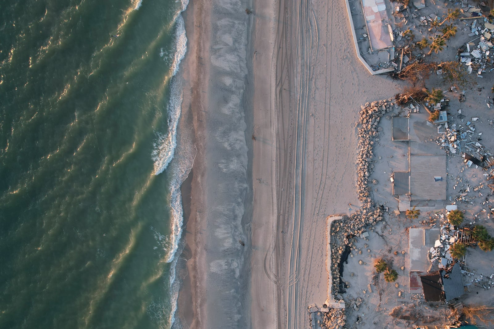 Waves roll in from the Gulf of Mexico toward lots where only empty foundations and debris remain after homes were swept away in Hurricane Milton, on Manasota Key in Englewood, Fla., Sunday, Oct. 13, 2024. (AP Photo/Rebecca Blackwell)