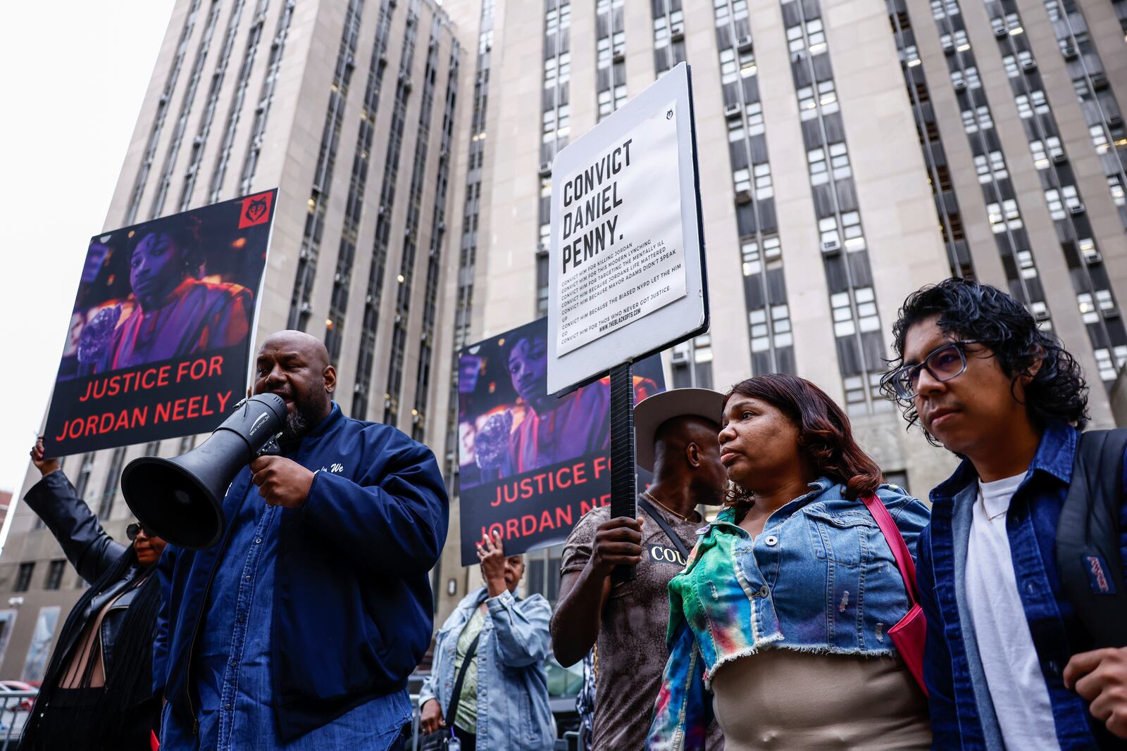 A Protestor speaks before Daniel Penny, the white veteran accused of choking a distressed Black subway rider to death, arrives for opening statements at the court in New York, Friday, Nov. 1, 2024.(AP Photo/Kena Betancur)