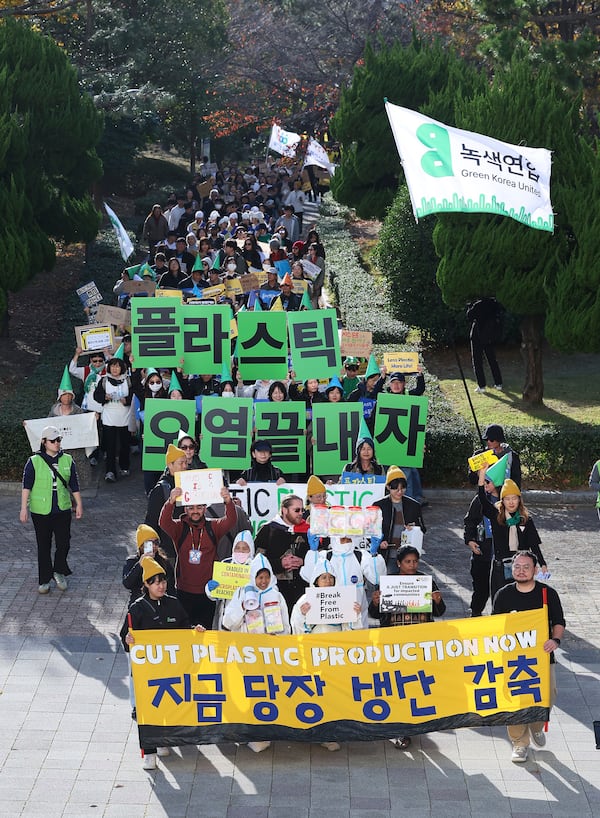 Environment activists march during a rally calling for a strong global plastics treaty ahead of the fifth session of the Intergovernmental Negotiating Committee on Plastic Pollution which sets to be held from Nov. 25 to Dec. 1 in Busan, South Korea, Saturday, Nov. 23, 2024. A signs at center reads "Let's end plastic pollution." (Son Hyung-joo/Yonhap via AP)