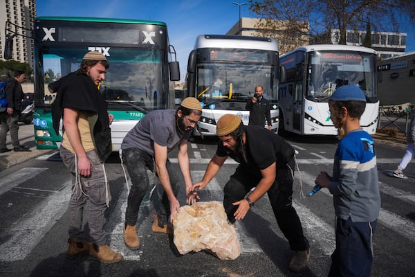 Activists representing families of Israelis who were killed during the war in Gaza block a road during a protest against the ceasefire deal between Israel and Hamas in Jerusalem on Thursday, Jan. 16, 2025. (AP Photo/Ohad Zwigenberg)