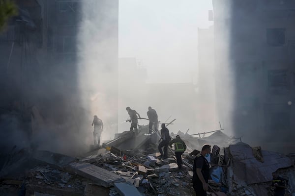 FILE - Civil defense workers extinguish a fire as smoke rises from the site of an Israeli airstrike in Tayouneh, Beirut, Lebanon, on Nov. 15, 2024. (AP Photo/Hassan Ammar, File)