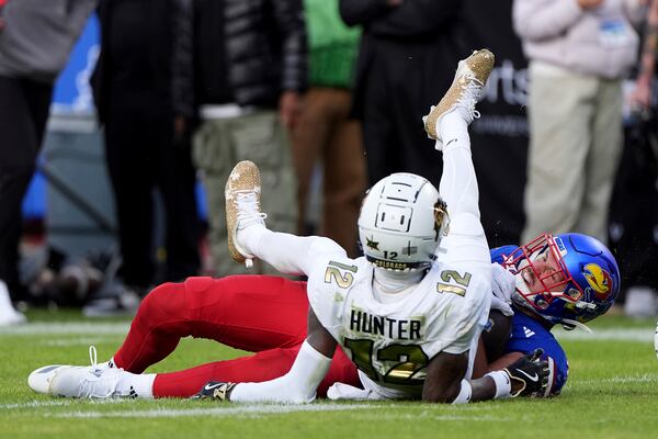 Kansas tight end Trevor Kardell (45) and Colorado corner back Travis Hunter (12) fall to the ground after Kardell made a first down during the first half of an NCAA college football game Saturday, Nov. 23, 2024, in Kansas City, Mo. (AP Photo/Charlie Riedel)