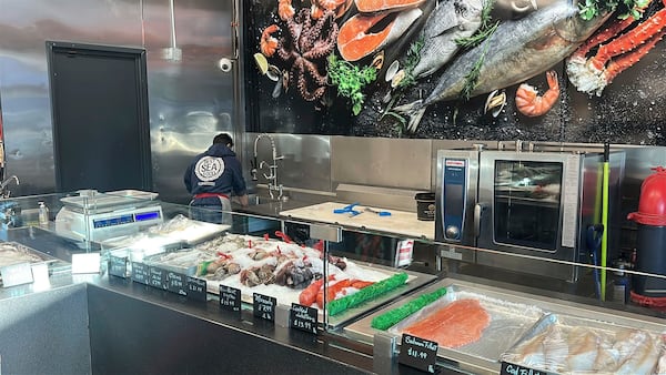 An employee of an Ocean Seafood Depot store works behind the counter, Friday, Jan. 24, 2025, in Newark, N.J. (AP Photo/Ted Shaffrey)