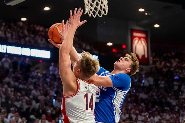 Duke guard Cooper Flagg, right, shoots around Arizona's Motiejus Krivas (14) during the first half of an NCAA college basketball game Friday, Nov. 22, 2024, in Tucson, Ariz. (AP Photo/Darryl Webb)