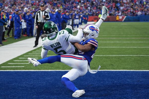 New York Jets wide receiver Garrett Wilson (5) makes a catch for a touchdown over Buffalo Bills cornerback Brandon Codrington (29) during the second half of an NFL football game, Sunday, Dec. 29, 2024, in Orchard Park, N.Y. (AP Photo/Gene J. Puskar)