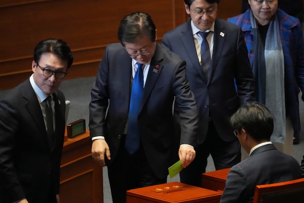 South Korea's main opposition Democratic Party leader Lee Jae-myung, center, casts a ballot on impeachment bills for the national Police Chief Cho Ji Ho and Justice Minister Park Sung Jae during a plenary session held relating to the martial law declaration, at the National Assembly in Seoul, South Korea, Thursday, Dec. 12, 2024. (AP Photo/Lee Jin-man)