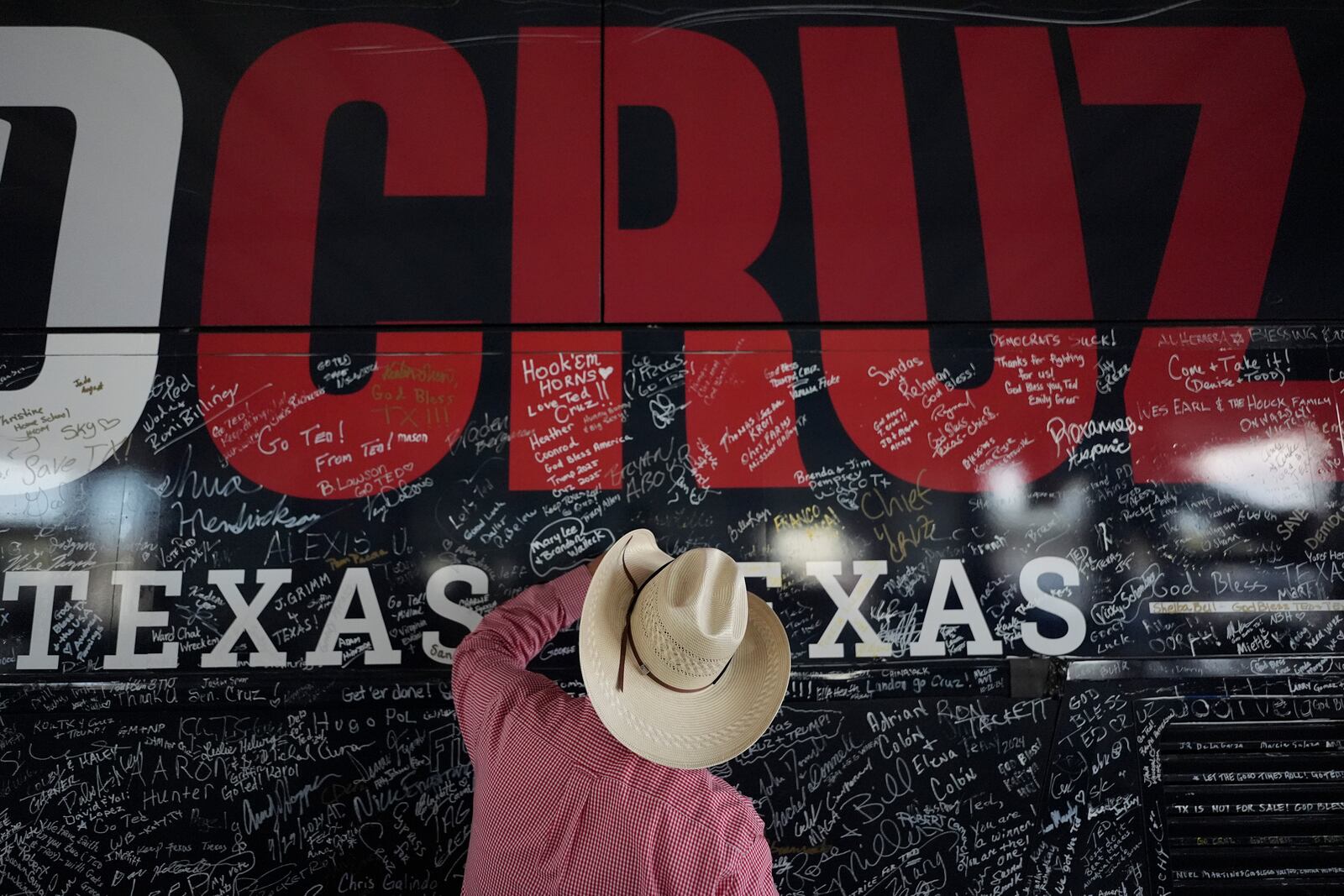 A supporter signs Sen. Ted Cruz's bus during a campaign rally Tuesday, Oct. 29, 2024, in Jourdanton, Texas. (AP Photo/Eric Gay)